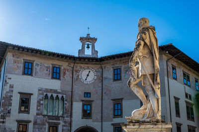 Low angle view of statue against building against sky