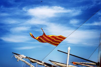 Low angle view of flags against blue sky