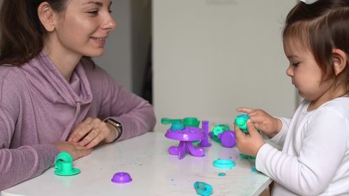 Portrait of smiling girl playing at table