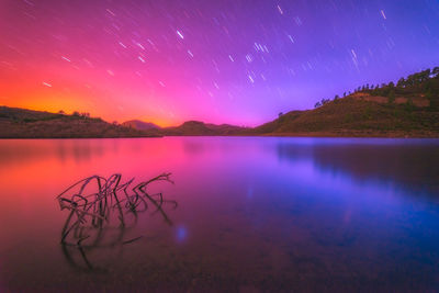 Scenic view of lake against sky at night