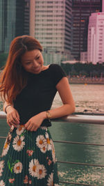 Young woman standing by water