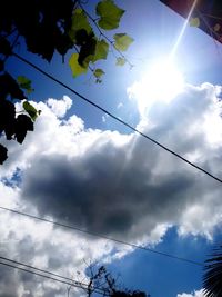 Low angle view of power lines against cloudy sky