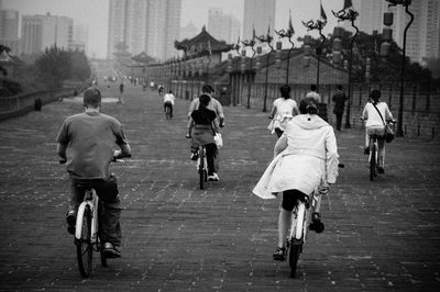 Rear view of people walking on street in city