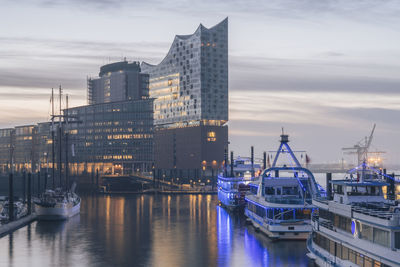 Germany, hamburg, boats moored in front of elbphilharmonie at dusk