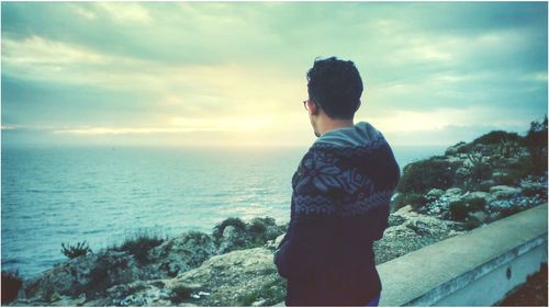 Man standing by sea against sky