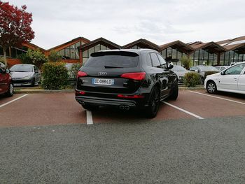 Cars on street in city against sky