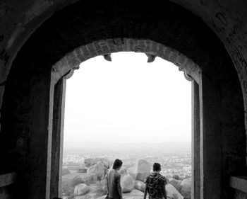 Rear view of people looking at archway