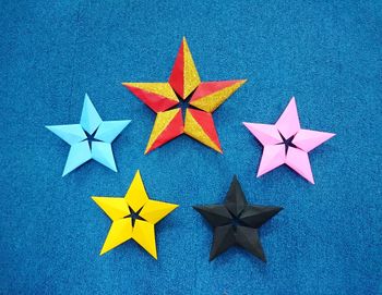 Close-up of colorful star shapes on blue wall