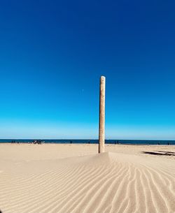 Scenic view of beach against clear blue sky