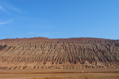 Scenic view of desert against blue sky