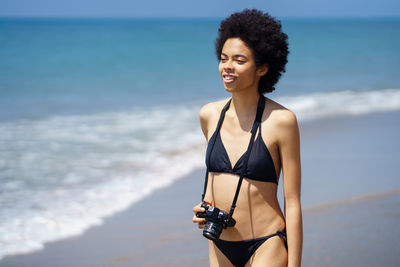 Portrait of young woman in bikini at beach
