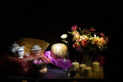 Flower vase on table against black background
