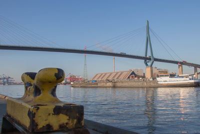 Suspension bridge over river against clear sky