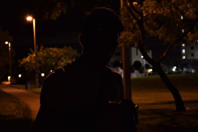 Silhouette man standing on street at night