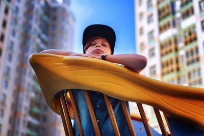 Low angle view of young man leaning on railing
