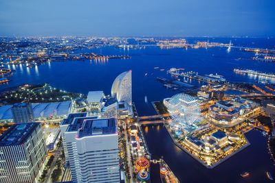 High angle view of illuminated cityscape against sky at dusk