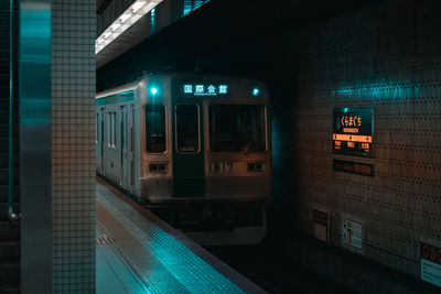 Train at railroad station platform at night