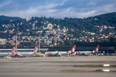 Airplane on airport runway against sky