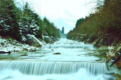 Scenic view of river against sky during winter