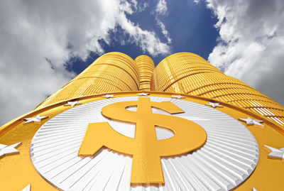 Stack of gold coins against cloudy sky