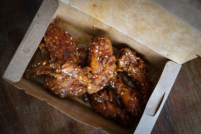 Korean fried chicken wings and drummets in a take away box. traditional asian recipe.