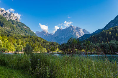 Scenic view of lake and mountains against blue sky