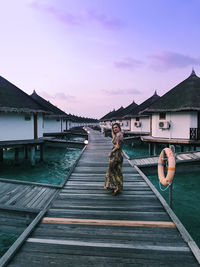 Full length of woman walking on pier over sea against sky