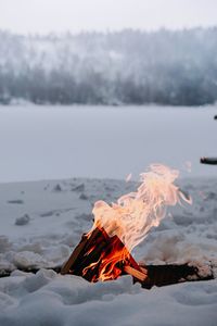 Tilt image of fire on land against sky during winter