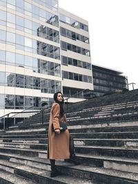 Full length of girl standing on staircase against building