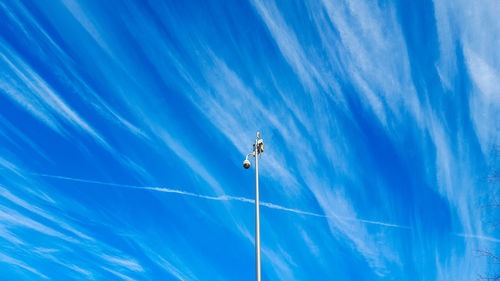 Low angle view of security camera against blue sky