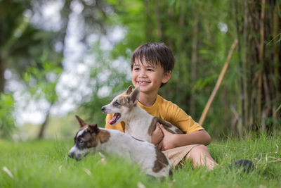 Cute boy with dog on grass