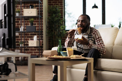 Man eating noodles at home