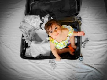 High angle portrait of cute baby lying on bed