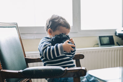 Boy sitting on chair at home