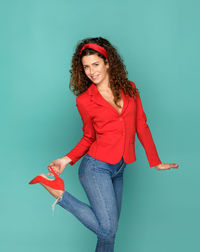 Young woman smiling while standing against blue background