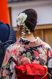 Rear view of woman holding umbrella