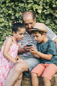 Happy friends sitting on mobile phone