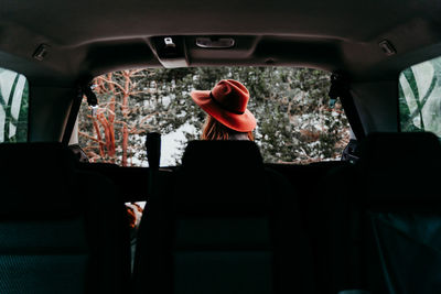 Rear view of woman sitting in car