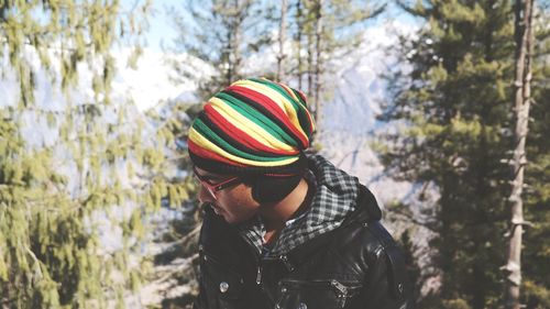 Man in hat against trees at forest