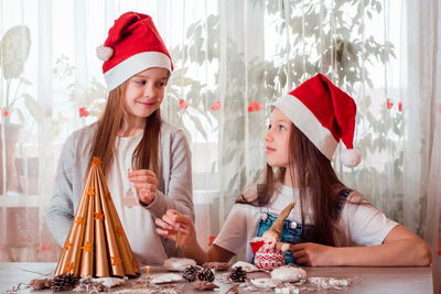 Christmas handmade. girls are going to decorate a homemade christmas tree with wooden toys