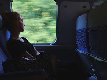 Rear view of woman sitting in train