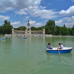 People in boat on water against cloudy sky