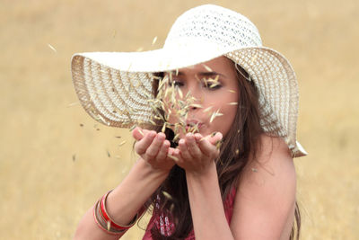 Close-up portrait of a young woman wearing hat