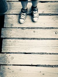 Low section of person standing on boardwalk