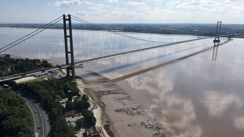 High angle view of suspension bridge against cloudy sky