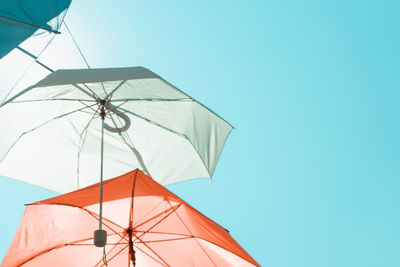 Low angle view of umbrella against clear blue sky