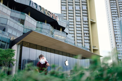 Woman standing by modern building in city