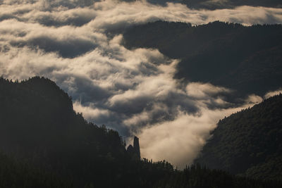 Low angle view of trees and mountains against sky