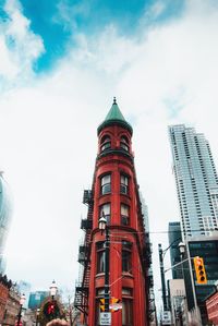 Low angle view of clock tower against cloudy sky