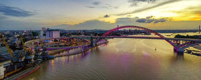 Bridge over river against sky during sunset